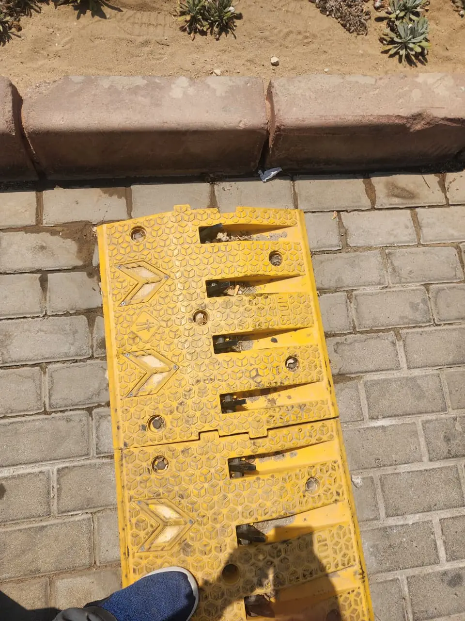 Yellow modular ramp section with chevron markings and channelled underside